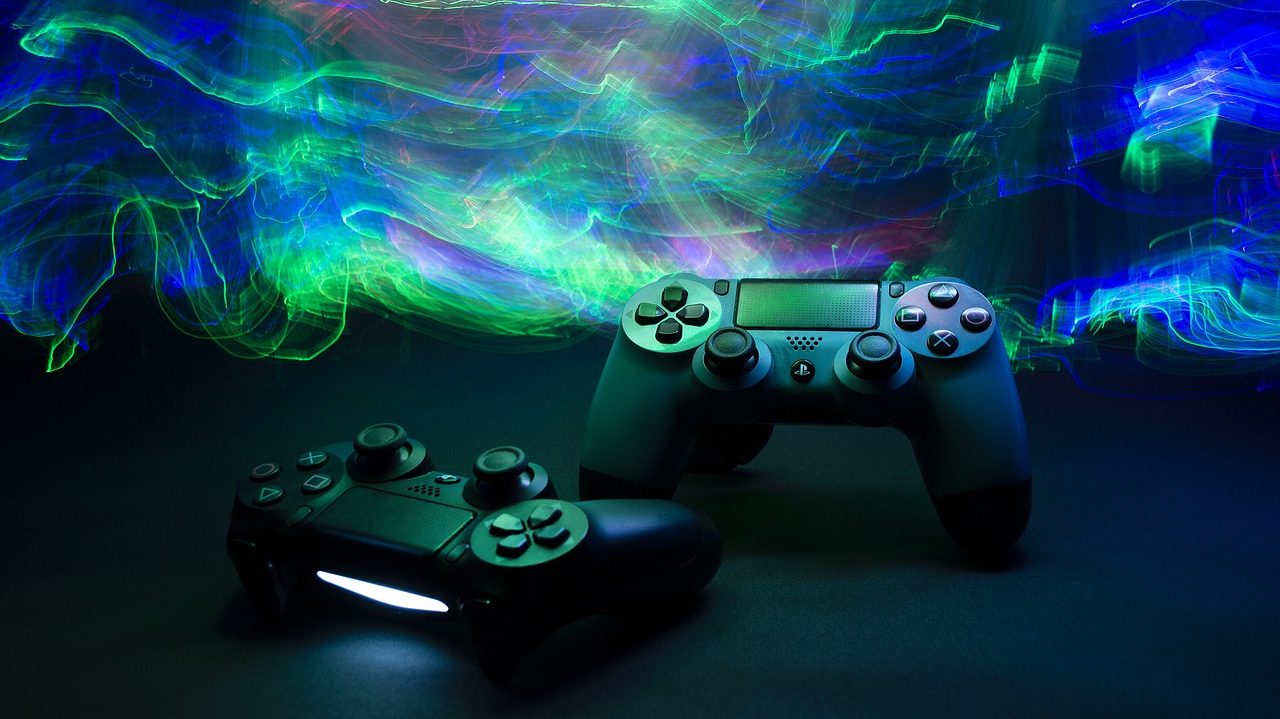 Image of two PlayStation controllers with neon green, blue, and pink light features in the background,